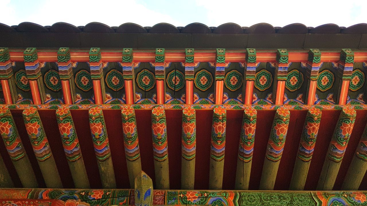 LOW ANGLE VIEW OF MULTI COLORED ROOF TILES ON BUILDING