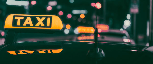 Close-up of taxi sign at night