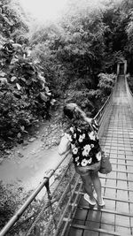 Rear view of woman walking on footbridge