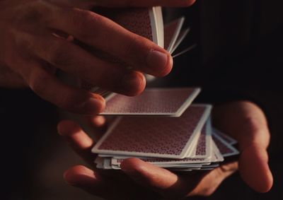 Midsection of man holding cards