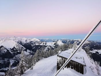 Scenic view of snow covered mountains against sky during sunset