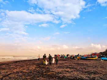 People on beach against sky