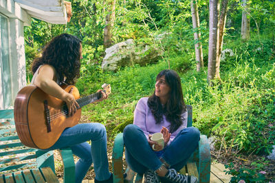 Young woman playing guitar in park