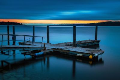 Pier on sea against sky at sunset