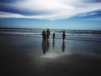 People on beach against sky