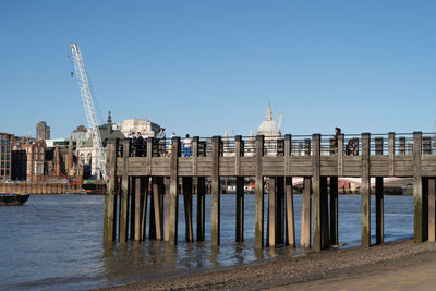 View of pier over sea against buildings in london city