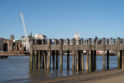 View of pier over sea against buildings in  london city