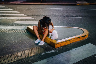 High angle view of woman sitting on road