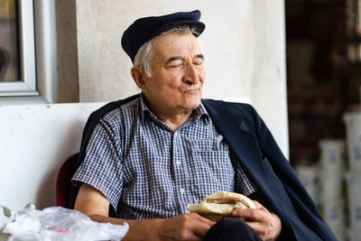 Portrait of man wearing hat while sitting outdoors