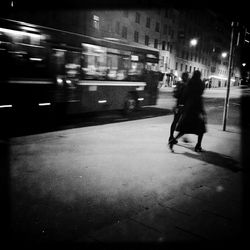 Blurred motion of woman in city at night