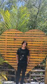 Portrait of young man standing against plants