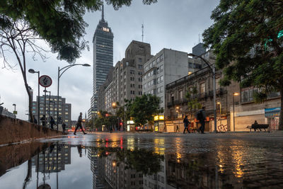 Reflection of buildings on wet street in rainy season