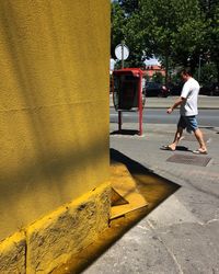 Side view of man walking on road