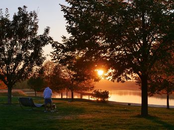 People sitting on bench in park during sunset