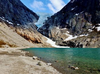 Scenic view of snowcapped mountains by lake against sky