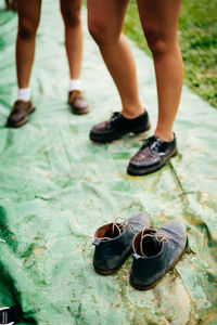 Low section of friends standing on tarpaulin