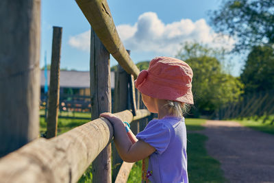 Side view of girl wearing hat standing outdoors