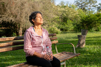 Senior woman sitting on bench in park