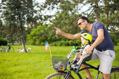 Side view of man riding bicycle on field