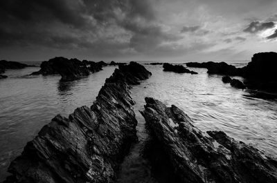Rock formations on shore against sky