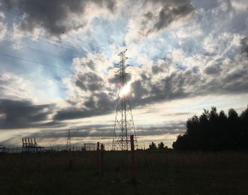 Low angle view of silhouette electricity pylon against sky