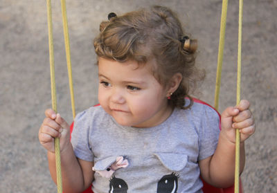 Close-up of cute girl on swing
