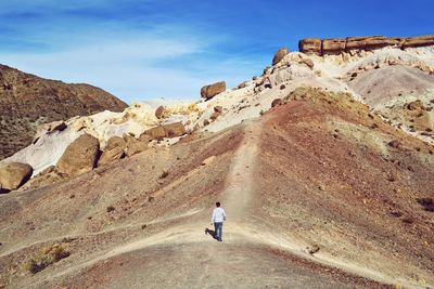 Man standing on rock formation at desert