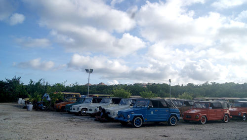 Cars on road against cloudy sky