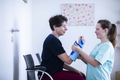 Nurse tigthing a armbracer to a patient female