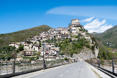 Road passing through mountain against blue sky