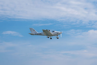 Low angle view of airplane flying against sky