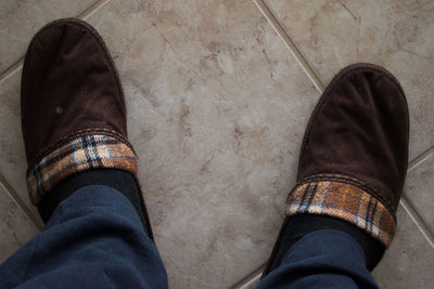 Low section of man standing on tiled floor