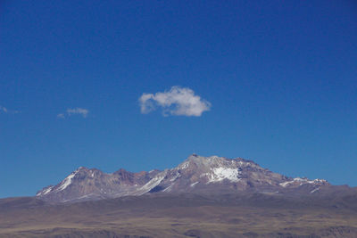 Scenic view of snowcapped mountains against blue sky