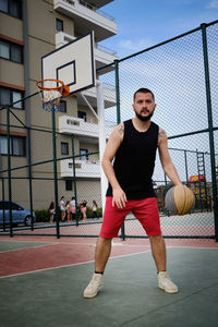 Young adult man plays basketball at outdoor court. basketball player shows his dribbling skill