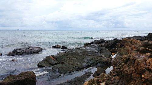 Rocks on sea shore against sky