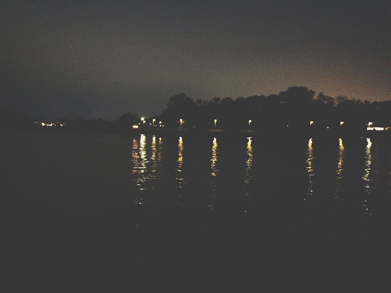 illuminated, night, water, reflection, silhouette, tranquil scene, copy space, waterfront, tranquility, lake, scenics, clear sky, sky, dark, sea, river, dusk, beauty in nature, nature, sunset