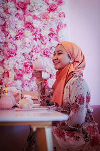 Woman with pink flowers on table