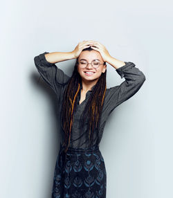 Portrait of young woman standing against white background