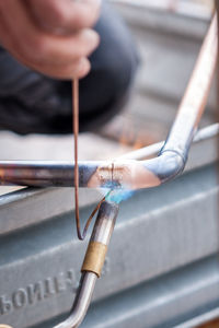 Close-up of person working on metal