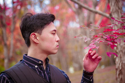 Portrait of young man looking away outdoors