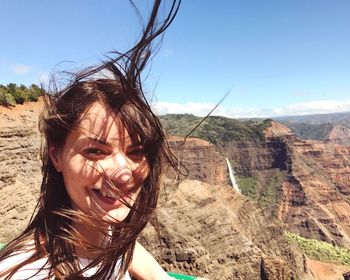 Close-up portrait of young woman against mountain