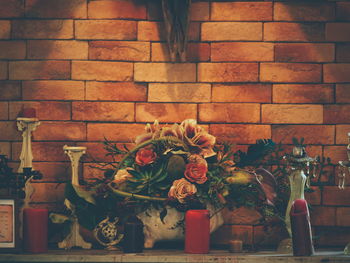 Close-up of vase against brick wall