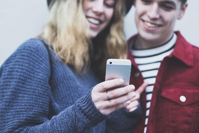 Midsection of couple looking at mobile phone