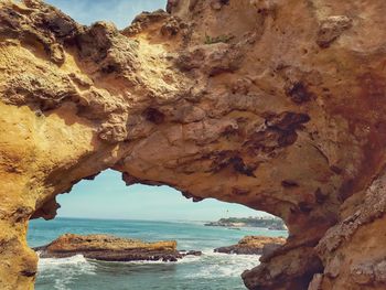 Scenic view of sea seen through cave