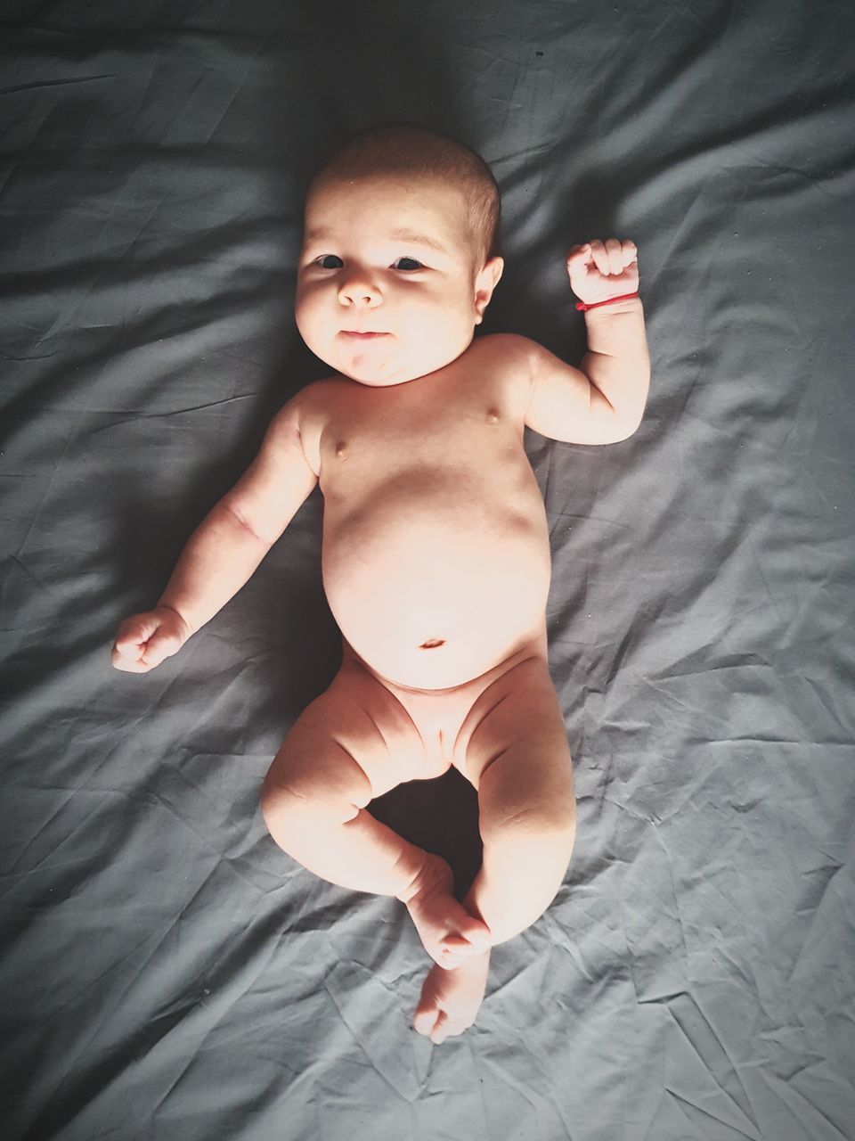 baby, bed, shirtless, indoors, high angle view, diaper, babyhood, one person, real people, bedroom, full length, directly above, lying on back, cute, childhood, sheet, babies only, portrait, day