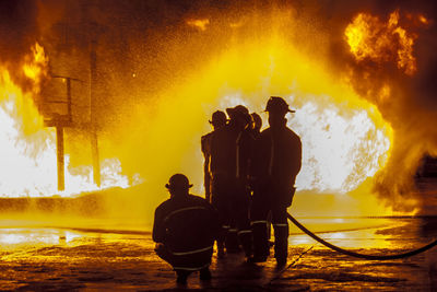 Firefighters spraying water on fire at night