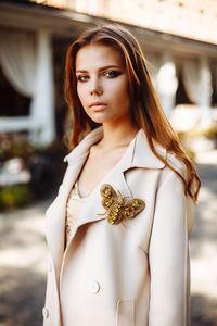 Fashionable young woman wearing overcoat in city