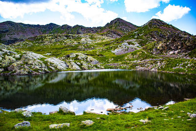 Scenic view of lake by mountains against sky