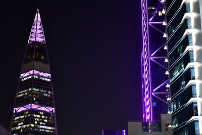 Low angle view of illuminated building against sky at night