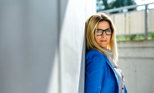 Portrait of woman standing against wall